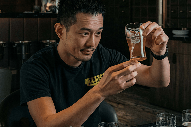 Ivan Yeo examining a cup of beer from The 1925 Brewing Co.